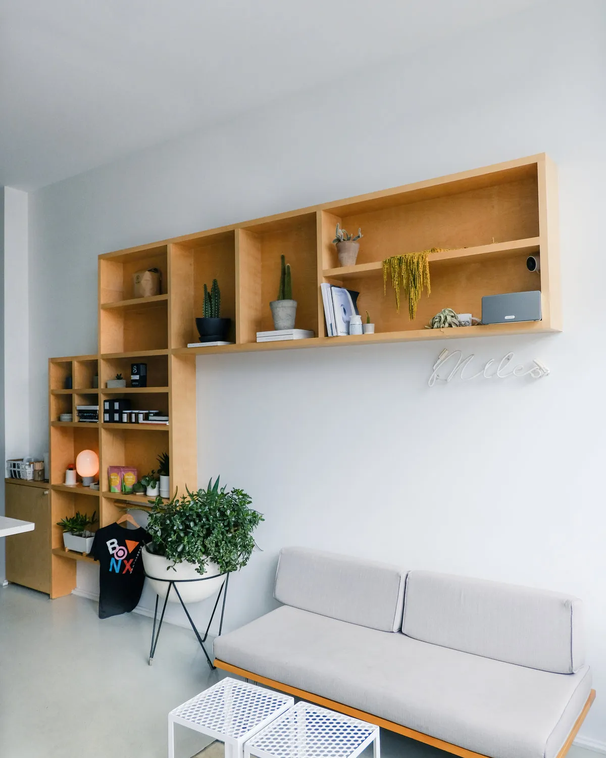 Jasny salon z sofą i drewnianym regałem